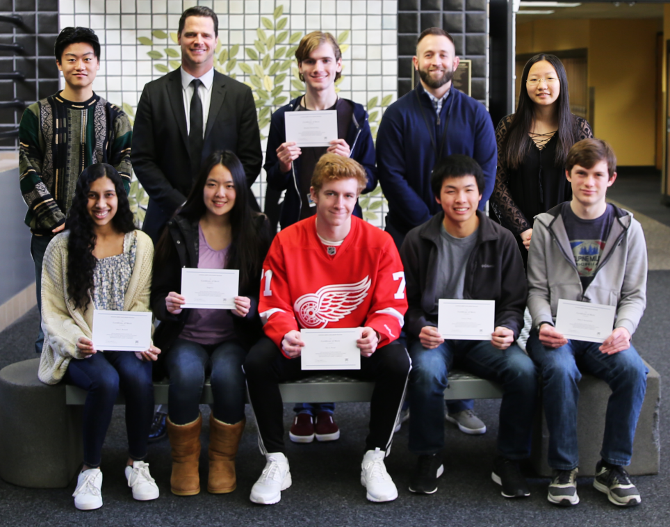 Penn High School Principal Sean Galiher and Counseling Center Director John Westra with Penn's eight National Merit Scholarship Finalists.