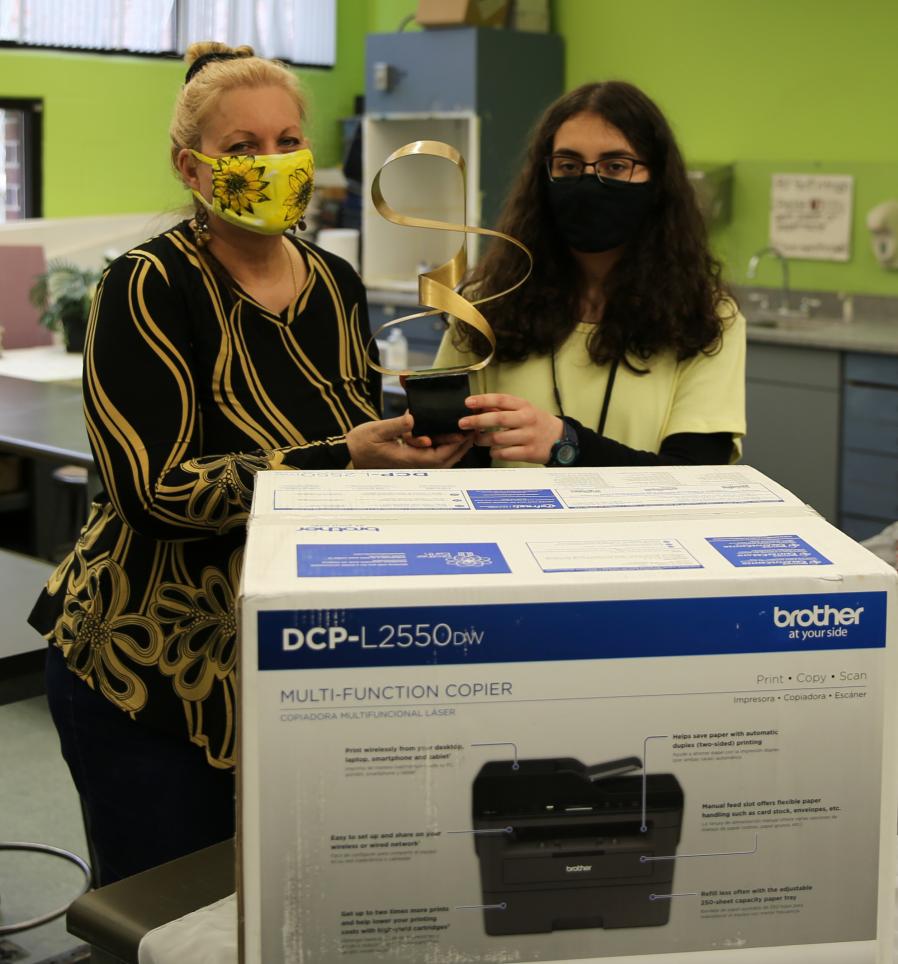 Penn Art Instructor Beth Loth presents the Grand Prize to Sophie Simonetti in the Penn Art mask competition.