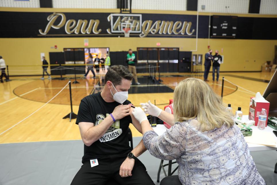 Meijer Clinical Pharmacy Specialist Amy Jennings administering vaccine to Penn Principal Sean Galiher