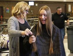 Ava Zachary is handed her hair that was cut to donate to people suffering from hair loss due to a medical condition.