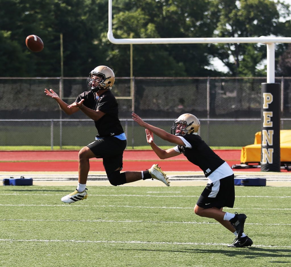 A Penn defensive back goes for the ball during a drill.