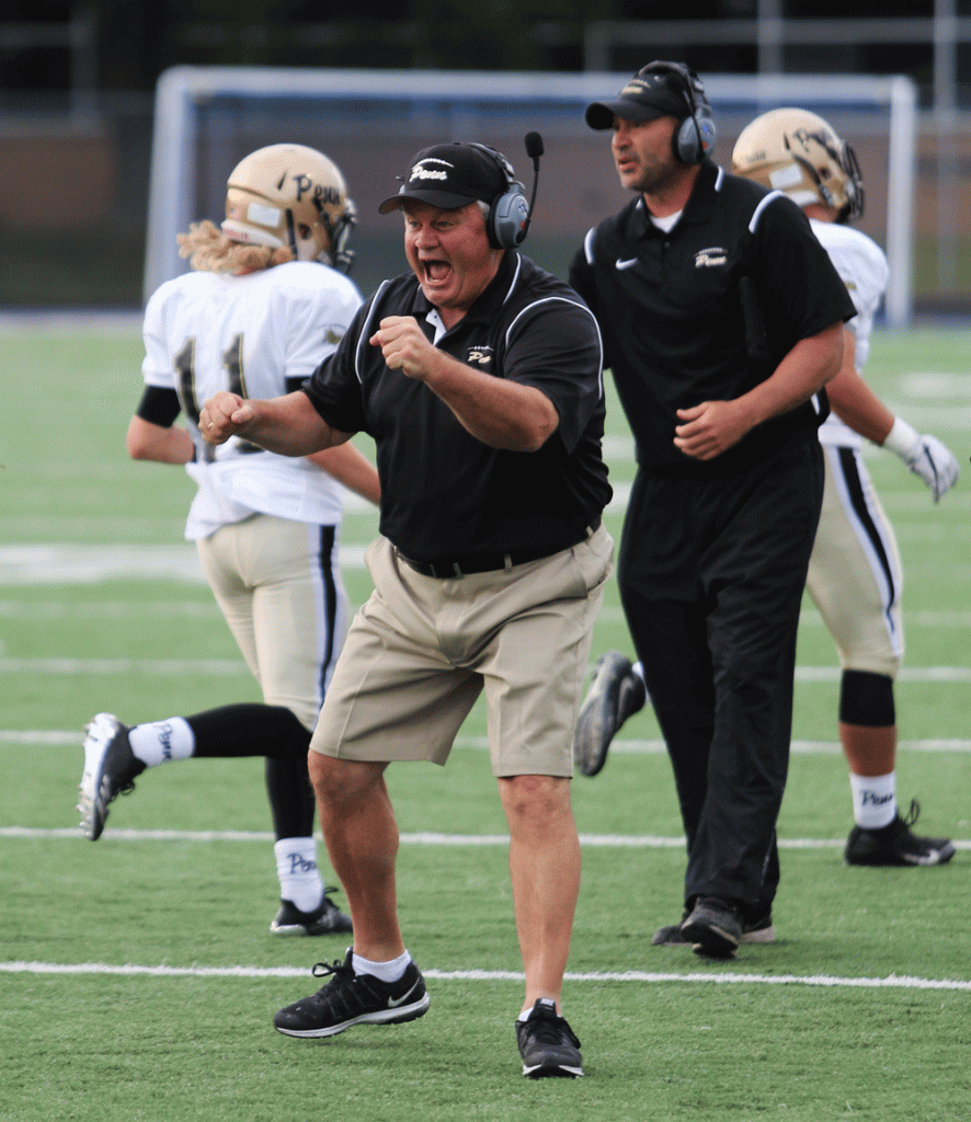 Penn coach Cory Yeoman celebrates points on the scoreboard.