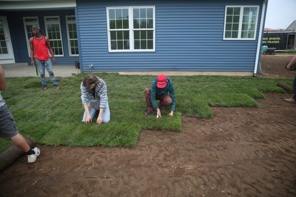 students laying sod at the house