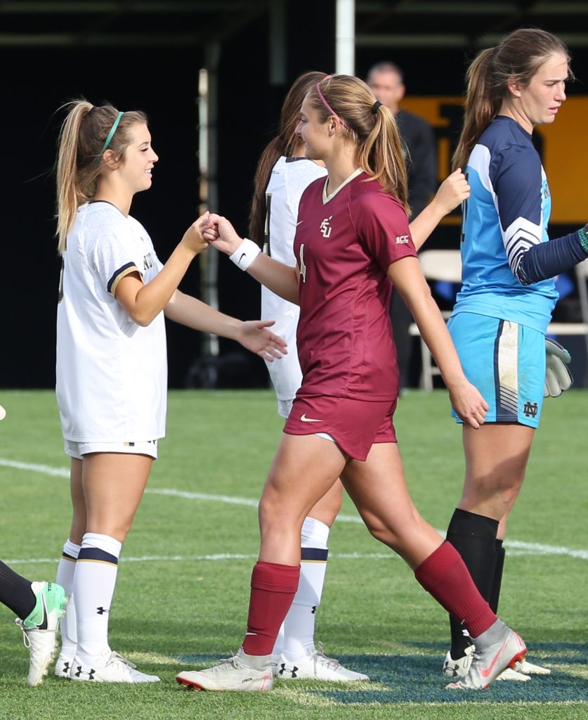Former Penn stars Brooke VanDyck, left, and Kristina Lynch bump fists before the Notre Dame vs. Florida State Women's Soccer match.