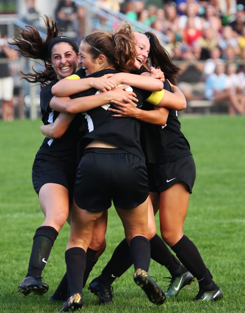 Penn Girls Soccer players celebrate a goal.