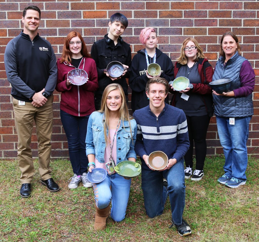 Penn High School Principal Sean Galiher, Ceramics Instructor Becky Brown with Penn Ceramics students who made food-safe ceramic bowls as a fundraiser for the Empty Bowls Project.
