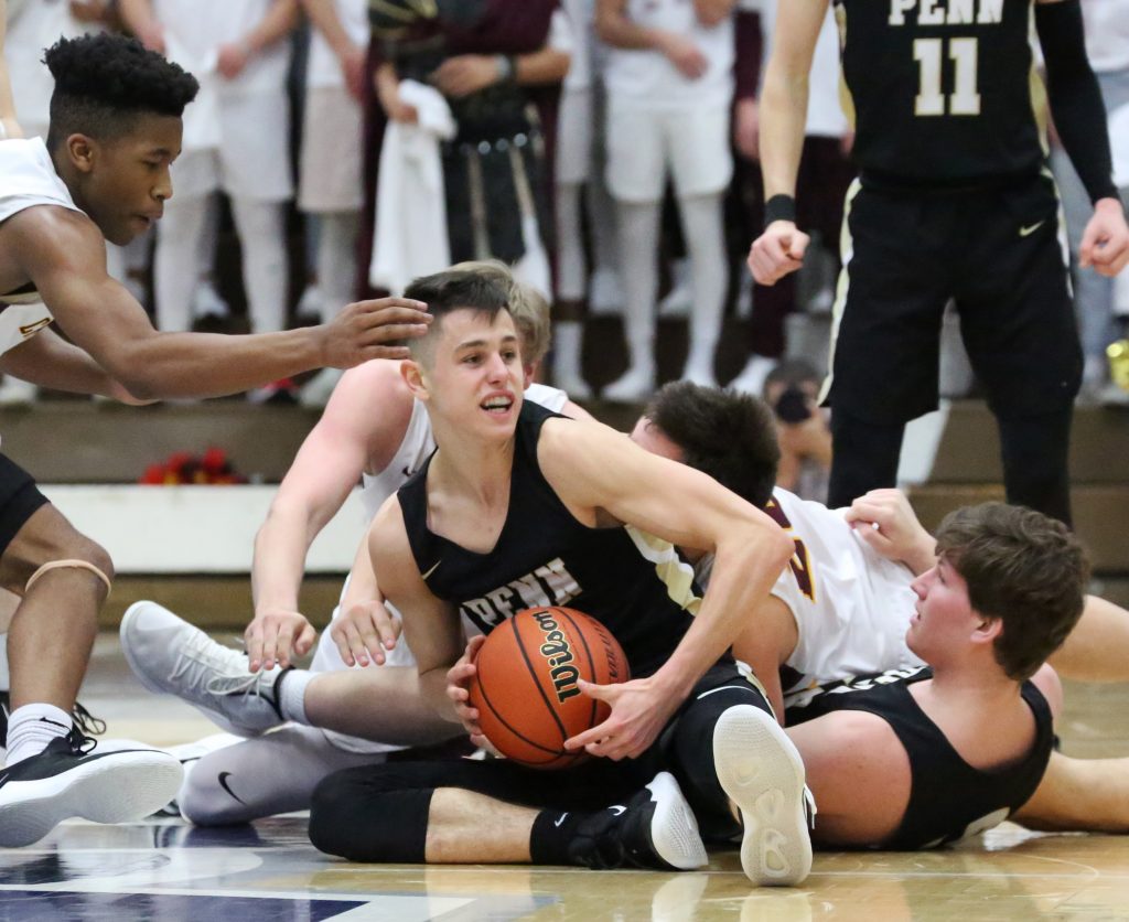 Penn Boys Basketball player Beau Ludwick outfights Chesterton players for control of the basketball.