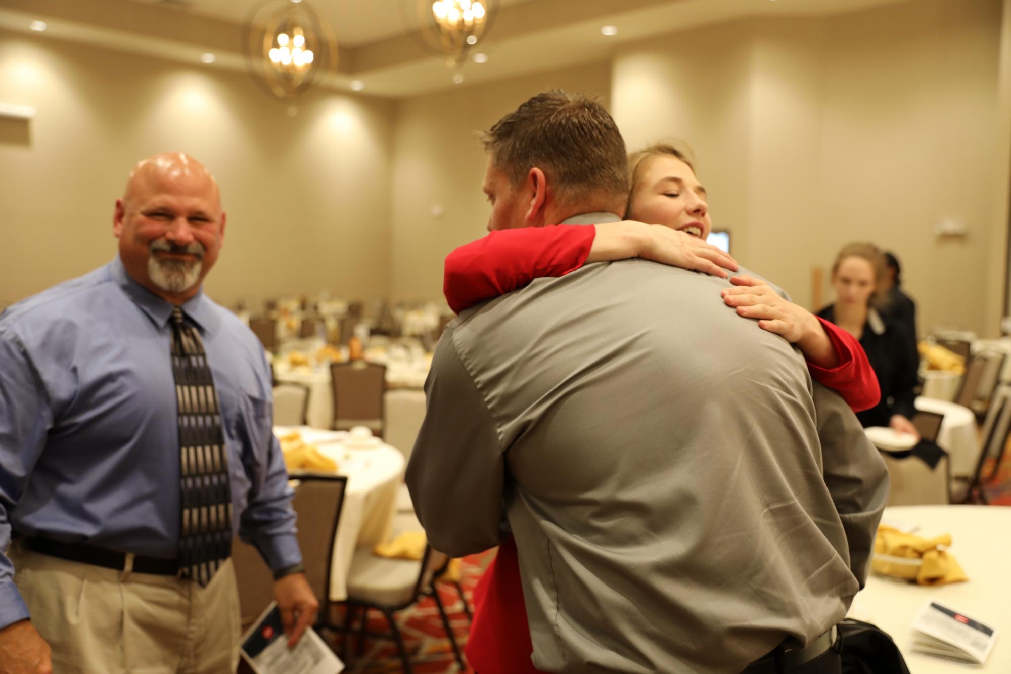 Sarah hugging her former Discovery wrestling coaches