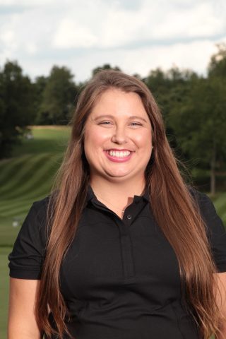 Woman in black shirt smiling at camera.