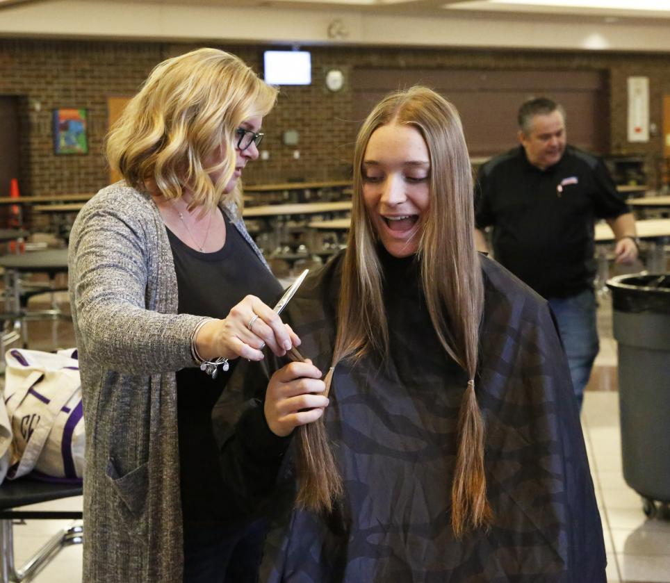 Ava Zachary is handed her hair that was cut to donate to people suffering from hair loss due to a medical condition.