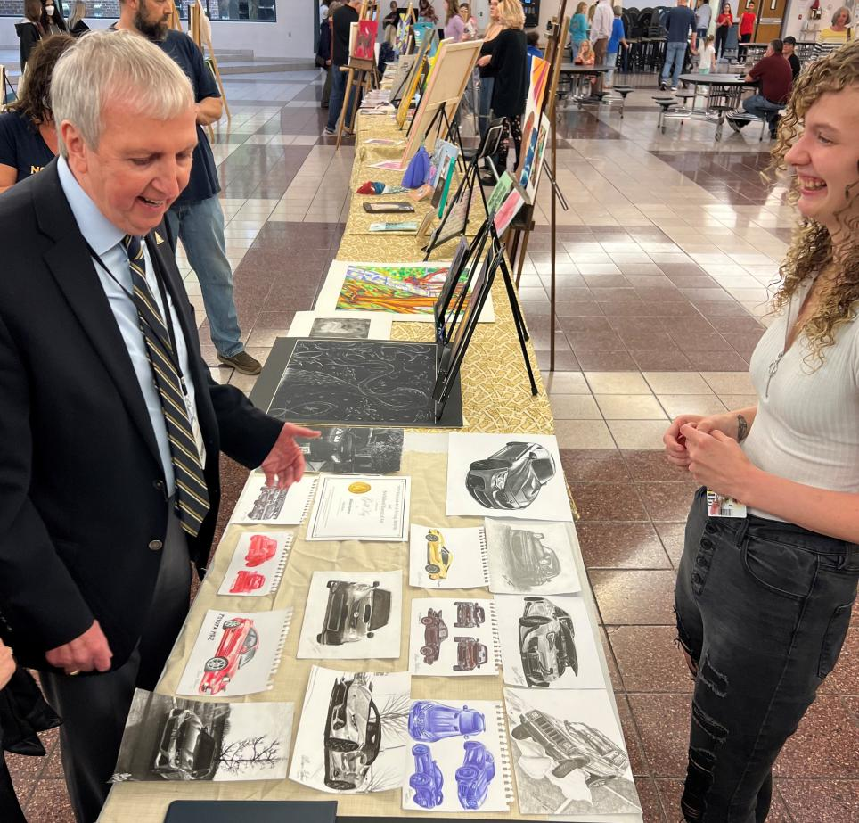 PHM Superintendent Dr. Jerry Thacker looks over the senior art projects