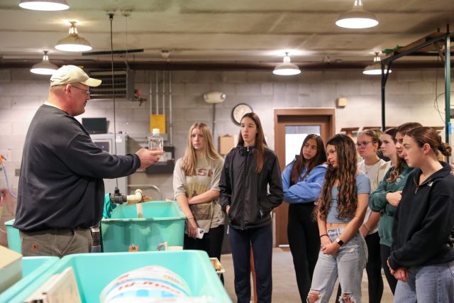 DNR Officer shows a lamprey to students during a field trip at the Bodine State Fish Hatchery in Mishawaka, Ind.