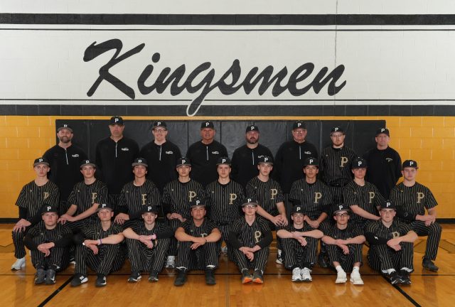 The team is posing together in front of a gymnasium wall.