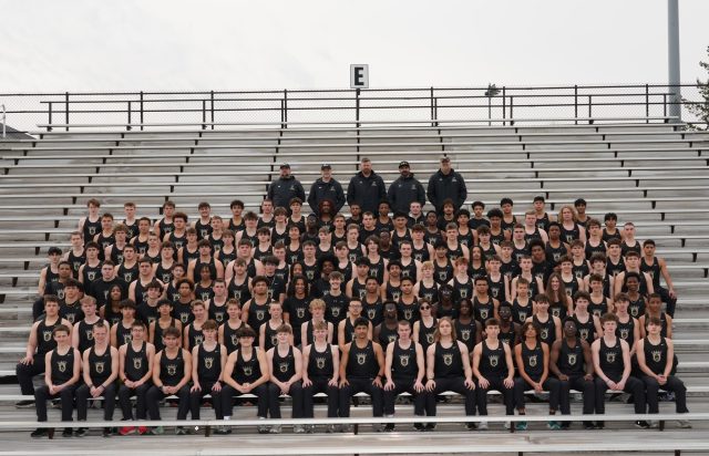 Team of Track & Field athletes posing for a group photo on bleachers.