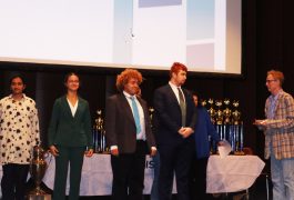 Students standing on stage at the Speech State Tournament, receiving awards.