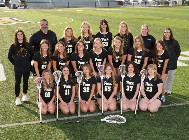The team of girls' lacrosse poses for a group photo on the field.