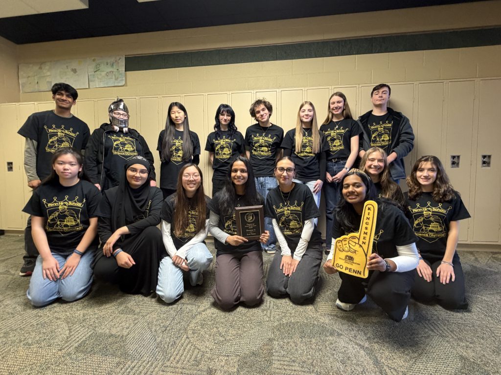 Group of people posing for a picture in front of a school building.