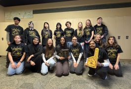 Group of people posing for a picture in front of a school building.