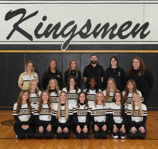 The team is posing for a group photo in front of a sign that reads kingsmen.