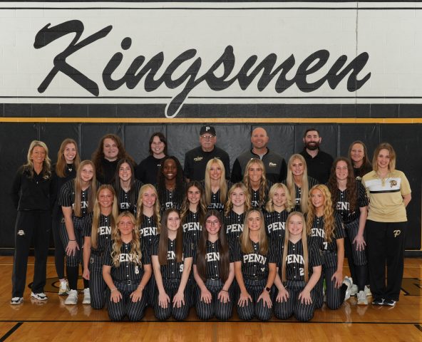 The Softball Team poses in a gymnasium.