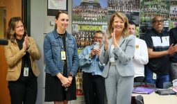 People in a room applauding someone at the front.