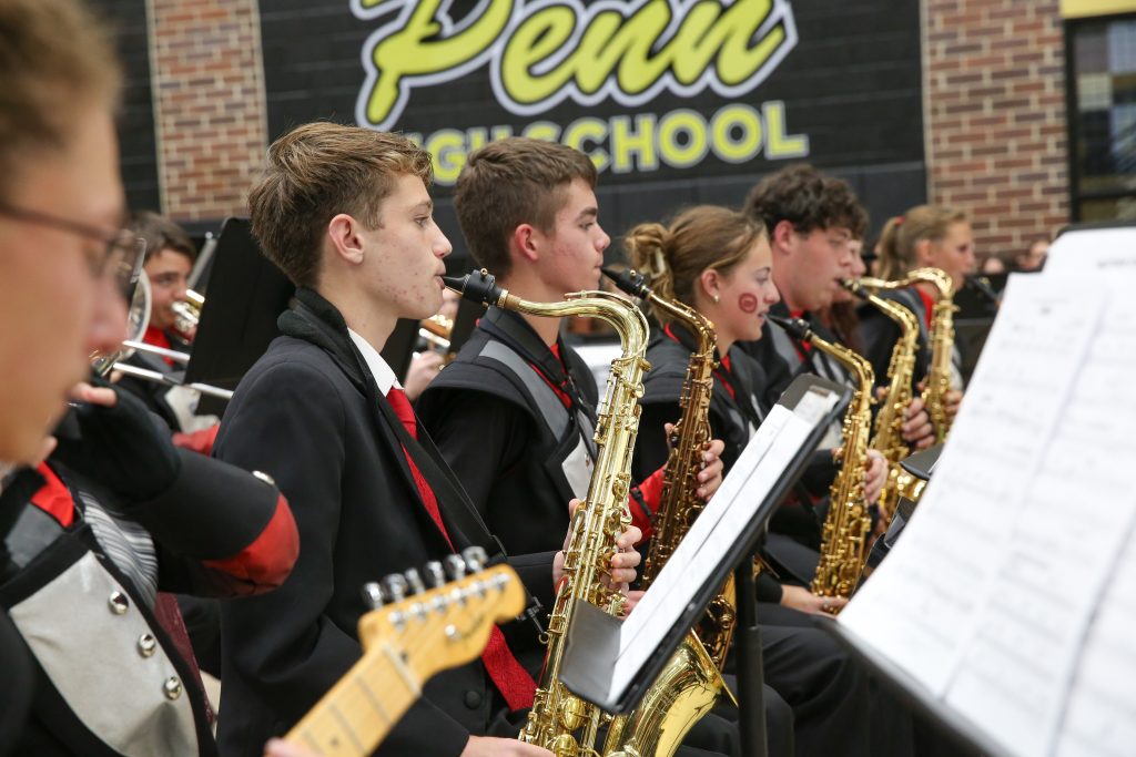 Young male musicians in a school band performing on stage.
