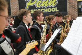 Young male musicians in a school band performing on stage.