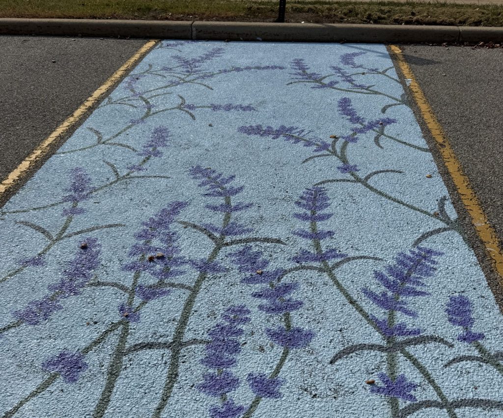 Blue parking space painted with purple flowers.