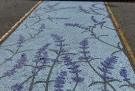 Blue parking space painted with purple flowers.