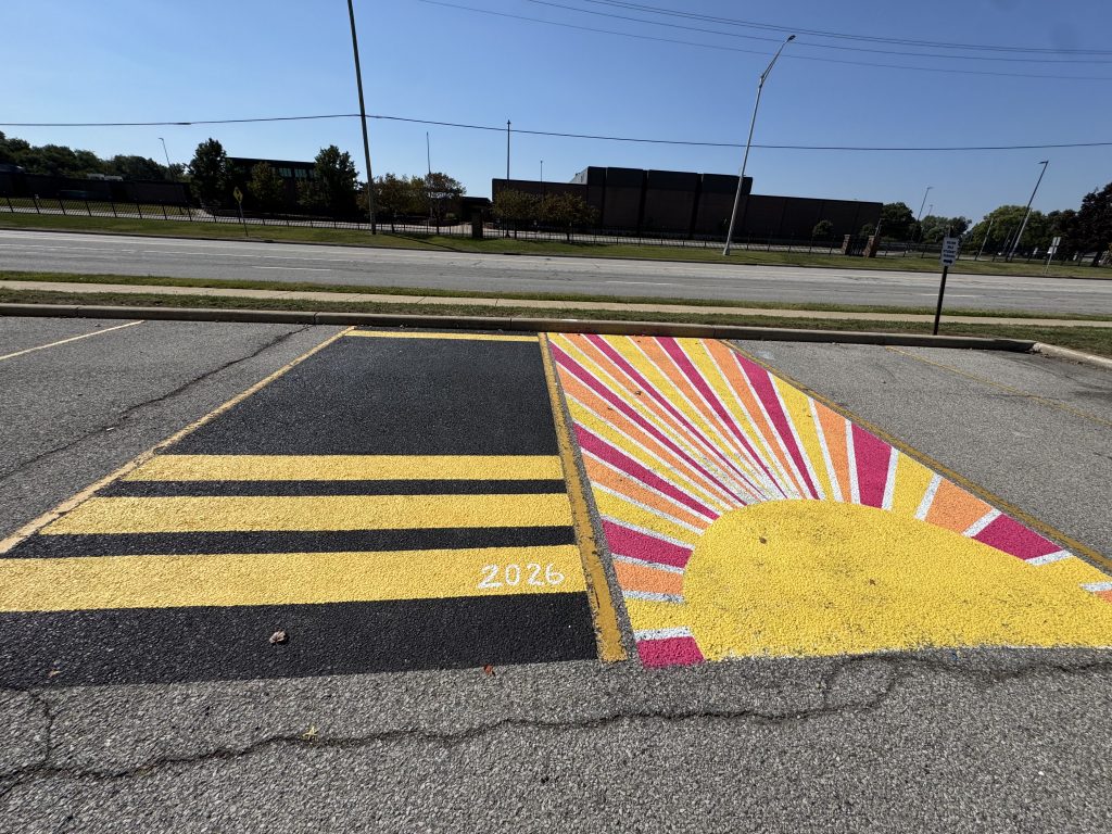 A composite of two photos showing a parking lot with a colorful painted sun design on a yellow curb.