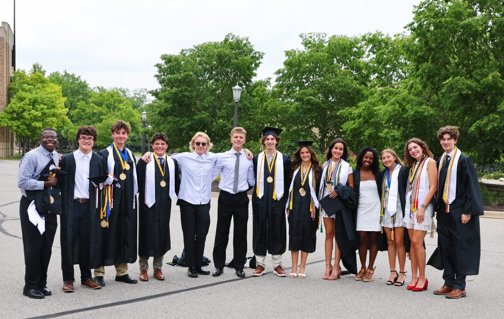 Group of graduates posing together in front of a building.