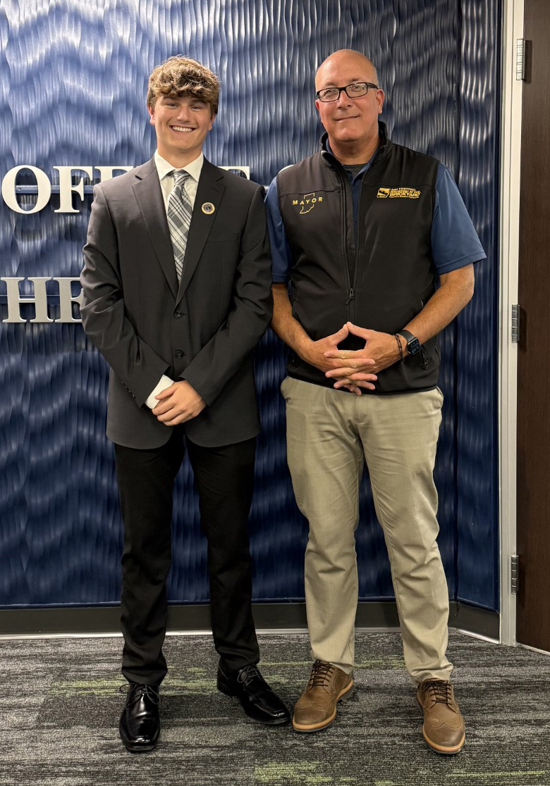 Two people posing for a photo in an office.