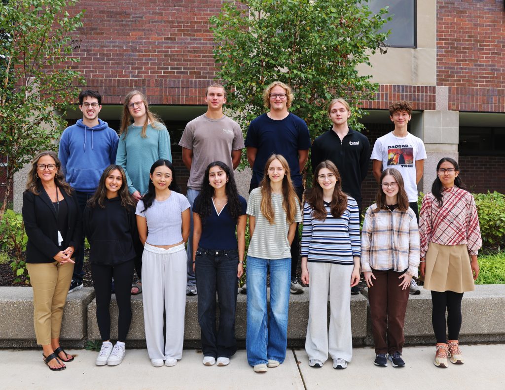 A group of people posing for a photo in front of a building.