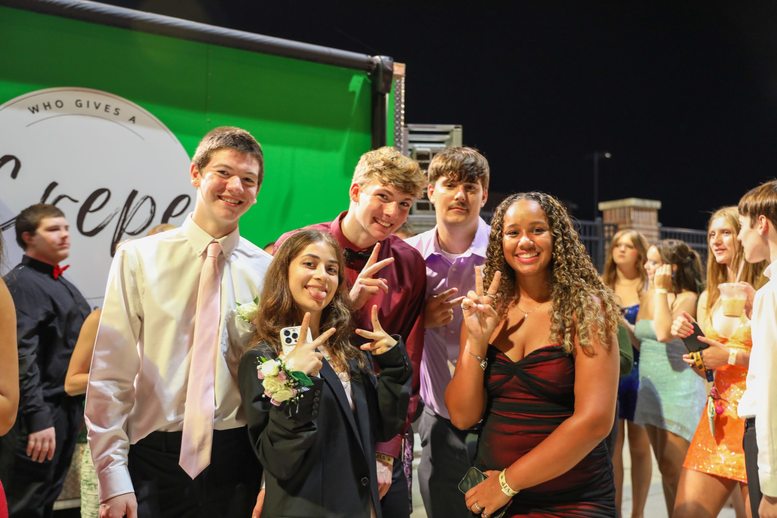 A group of people posing for a photo at night.